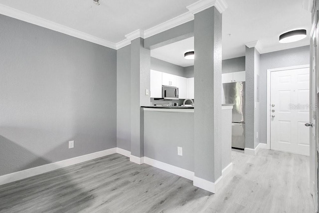 kitchen featuring stainless steel appliances, white cabinetry, crown molding, and light hardwood / wood-style floors