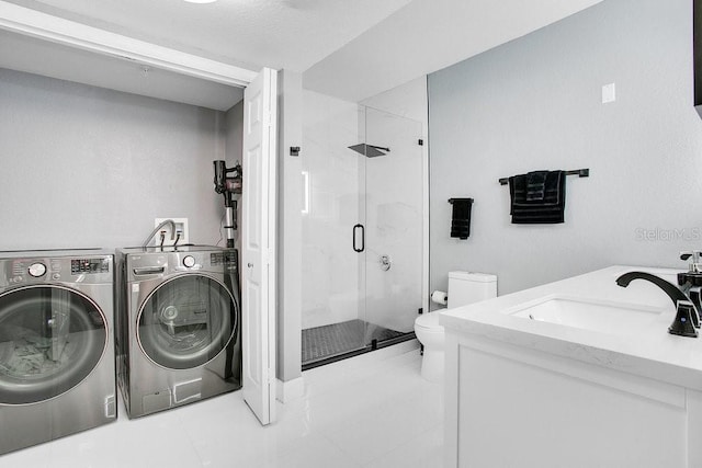 laundry room featuring separate washer and dryer, sink, and light tile patterned floors