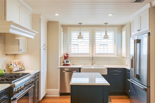 kitchen featuring sink, a center island, high end appliances, decorative backsplash, and hanging light fixtures