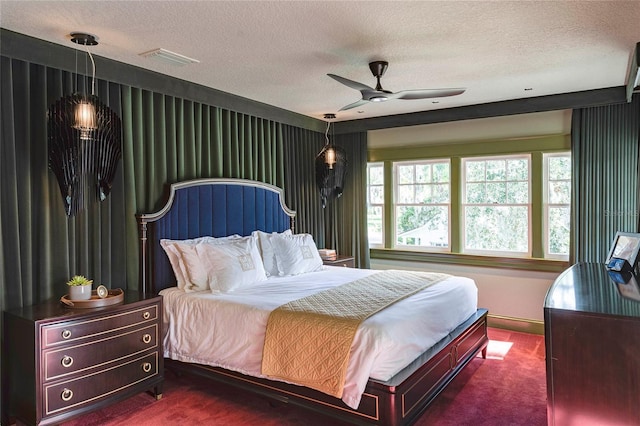 bedroom with a textured ceiling, ceiling fan, and carpet