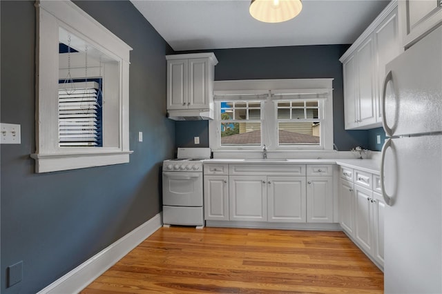 kitchen featuring sink, white appliances, white cabinetry, and light wood-type flooring