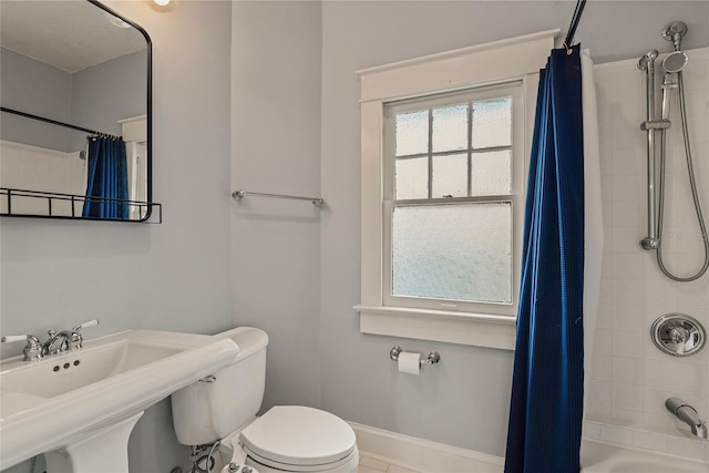 full bathroom featuring sink, shower / bath combo, and toilet