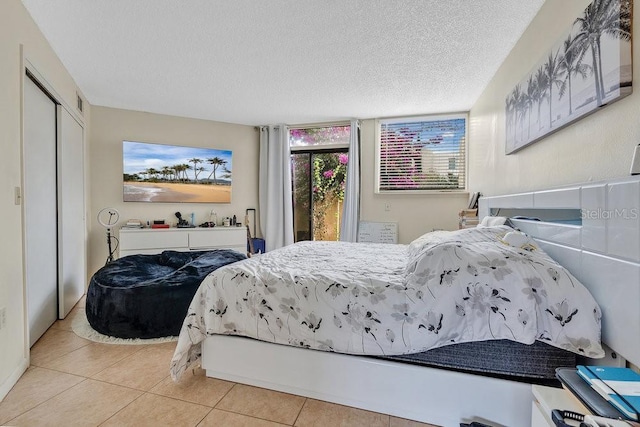 bedroom with light tile patterned floors and a textured ceiling