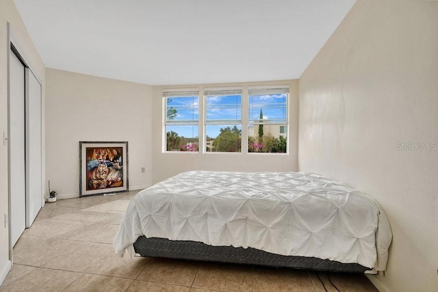 bedroom featuring light tile patterned floors and a closet