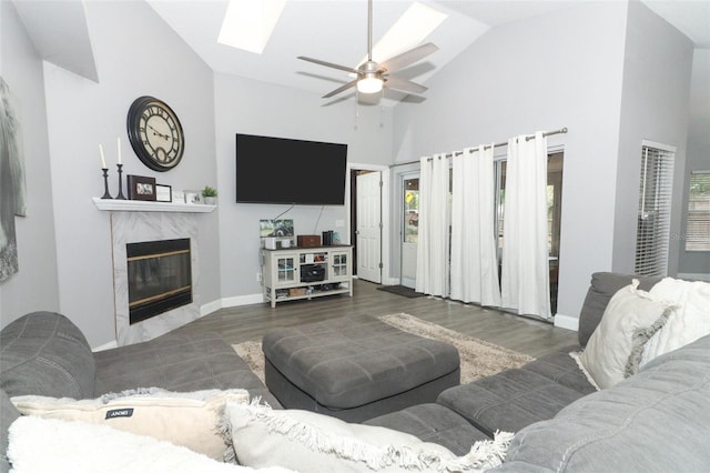 living room with a premium fireplace, dark hardwood / wood-style flooring, ceiling fan, and high vaulted ceiling