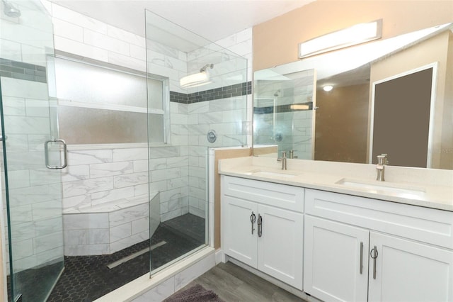 bathroom featuring vanity, wood-type flooring, and a shower with door