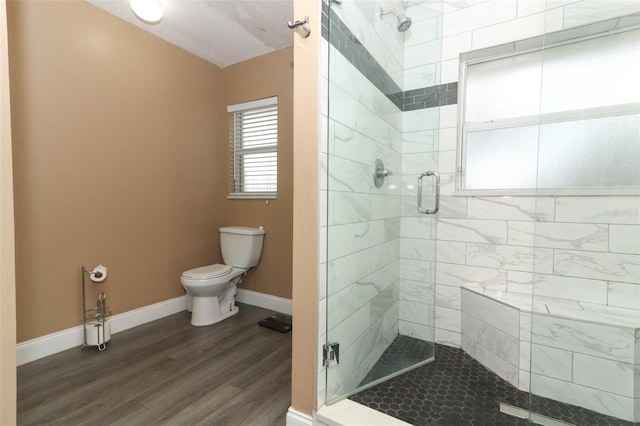 bathroom with hardwood / wood-style flooring, toilet, and walk in shower