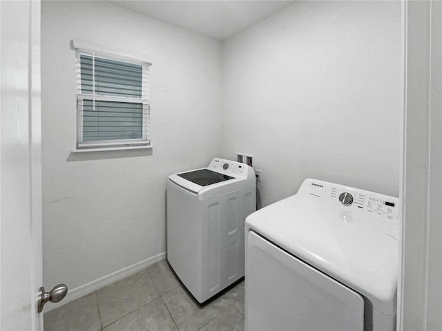 laundry area featuring washing machine and dryer and light tile patterned floors