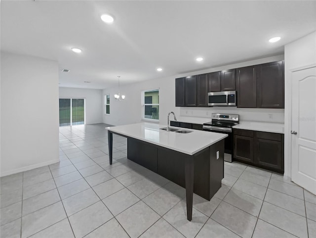 kitchen with stainless steel appliances, sink, hanging light fixtures, a breakfast bar area, and an island with sink