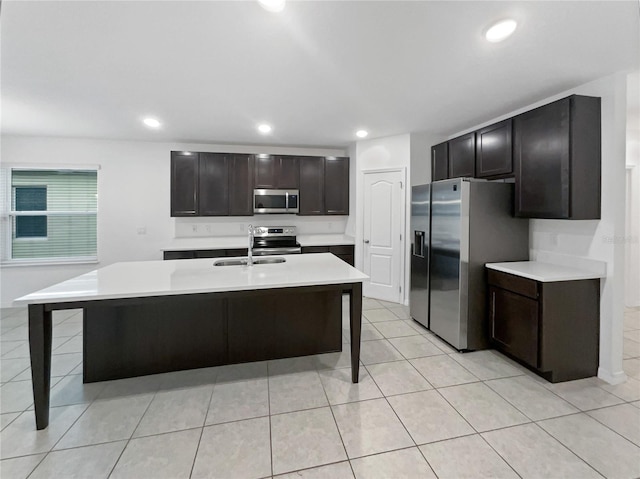 kitchen featuring sink, a kitchen bar, stainless steel appliances, and a kitchen island with sink