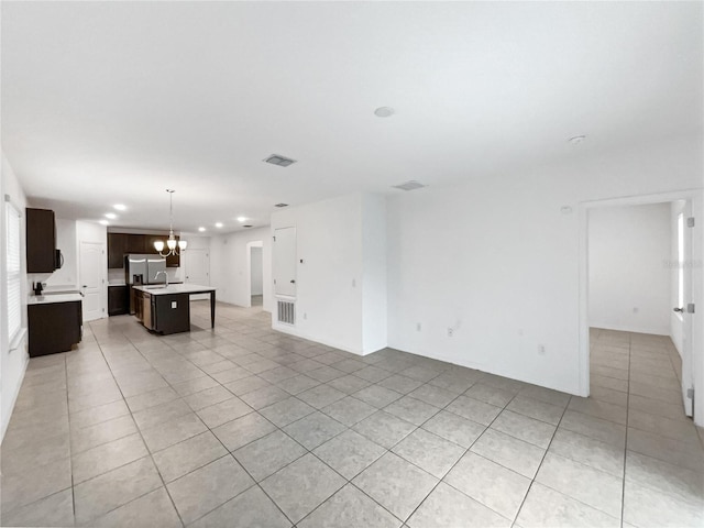 unfurnished living room featuring light tile patterned floors and an inviting chandelier