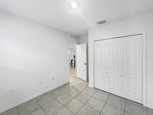 unfurnished bedroom featuring light tile patterned flooring and a closet