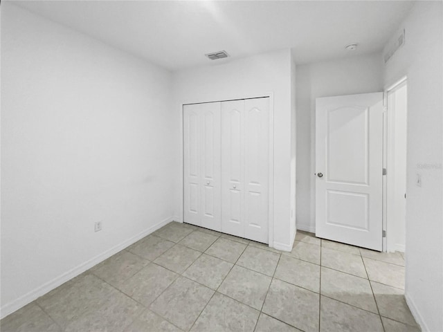 unfurnished bedroom with light tile patterned floors and a closet