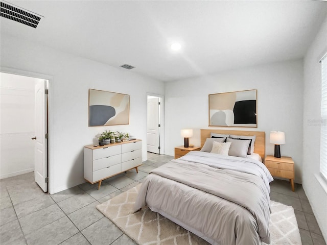 bedroom featuring connected bathroom and light tile patterned flooring