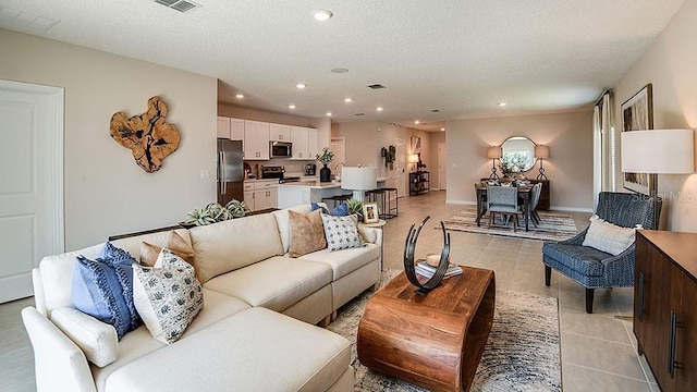 tiled living room featuring a textured ceiling