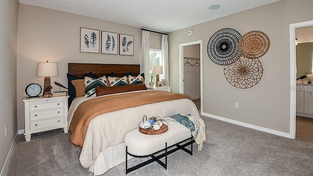 carpeted bedroom featuring a textured ceiling, a spacious closet, and a closet