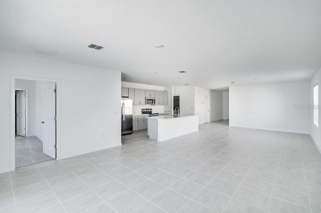 unfurnished living room featuring sink