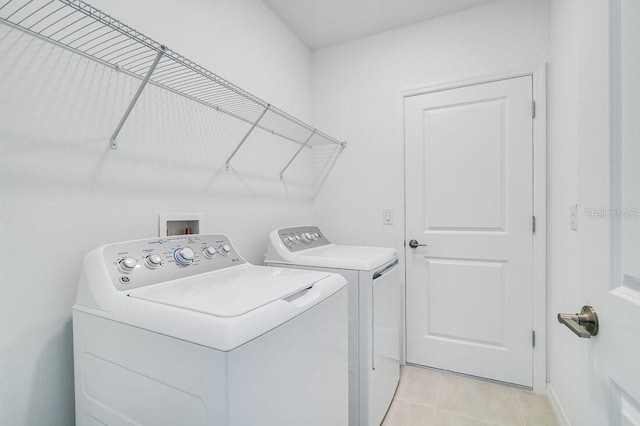 laundry area featuring separate washer and dryer and light tile patterned floors