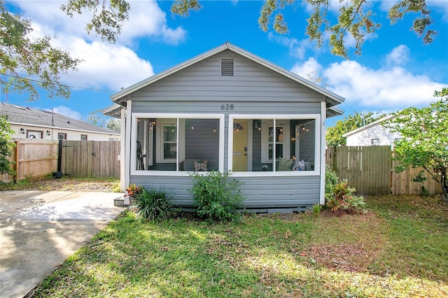 bungalow featuring a sunroom and a front yard