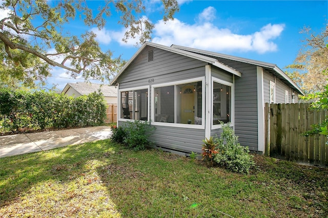 back of property featuring a yard and a sunroom