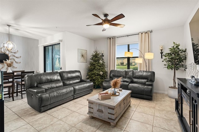 tiled living room with ceiling fan with notable chandelier