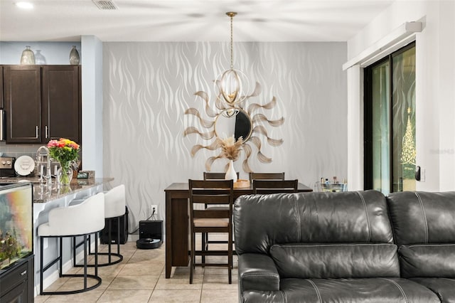 tiled living room with a notable chandelier