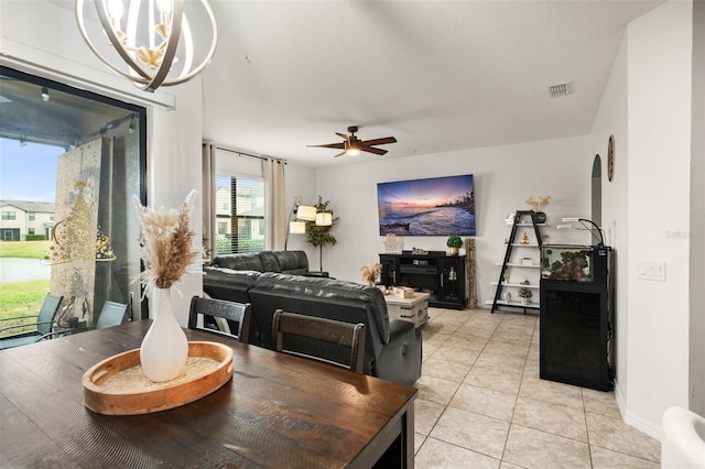 living room with light tile patterned floors and ceiling fan with notable chandelier