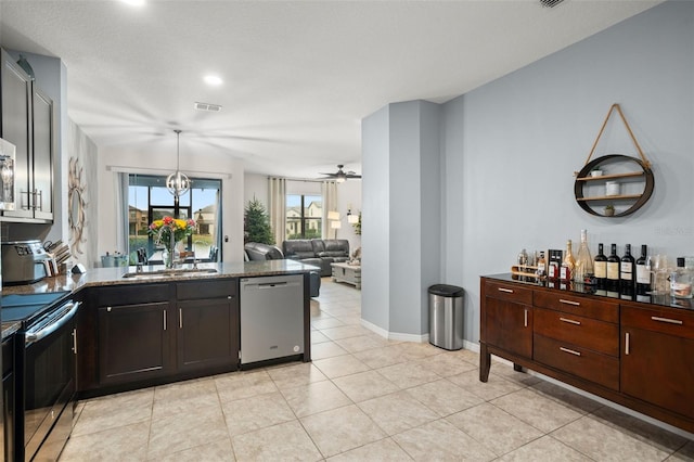 kitchen with ceiling fan with notable chandelier, sink, light tile patterned floors, appliances with stainless steel finishes, and dark brown cabinetry