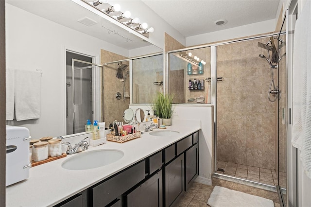 bathroom featuring tile patterned flooring, vanity, and a shower with shower door