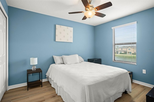 bedroom with ceiling fan, light wood-type flooring, and a closet