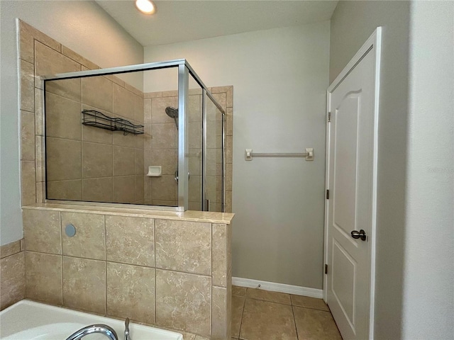 bathroom featuring tile patterned flooring and a tile shower