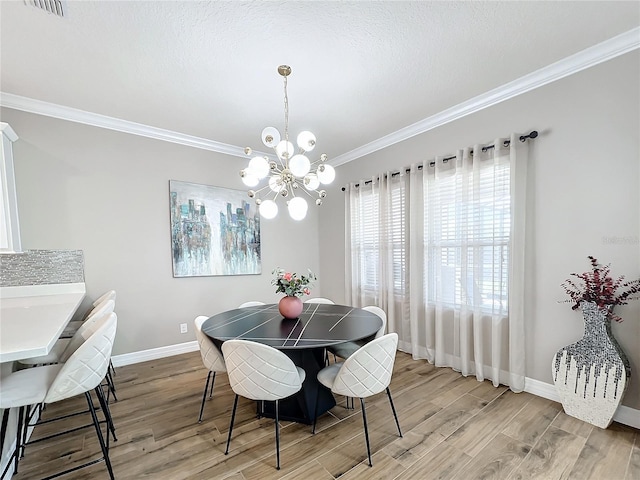 dining area with a chandelier, light hardwood / wood-style floors, and ornamental molding