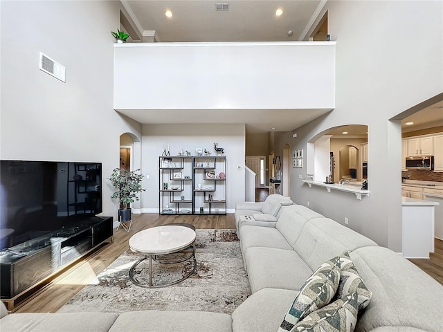 living room with a high ceiling and hardwood / wood-style flooring