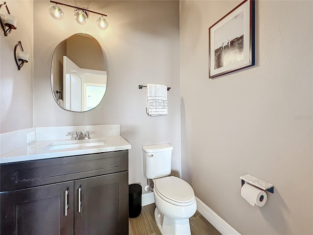 bathroom with hardwood / wood-style floors, vanity, and toilet