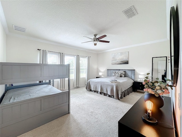 bedroom with ceiling fan, light colored carpet, a textured ceiling, and ornamental molding