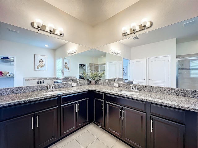 bathroom with tile patterned floors, vanity, and an enclosed shower