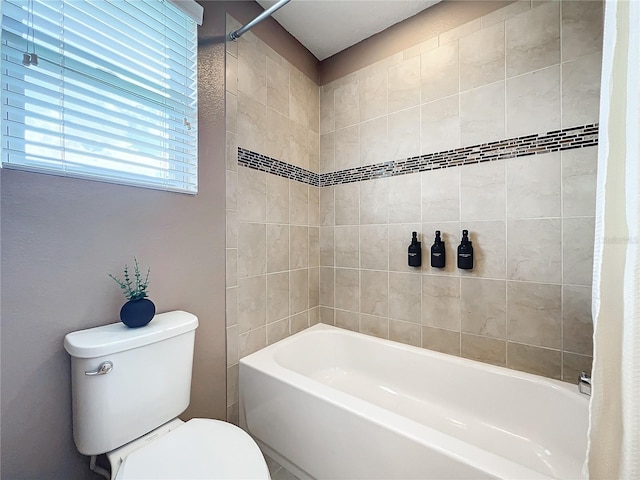 bathroom with toilet and tiled shower / bath