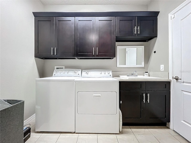 washroom with cabinets, light tile patterned floors, sink, and washing machine and clothes dryer