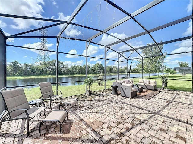 view of patio / terrace featuring outdoor lounge area, glass enclosure, and a water view