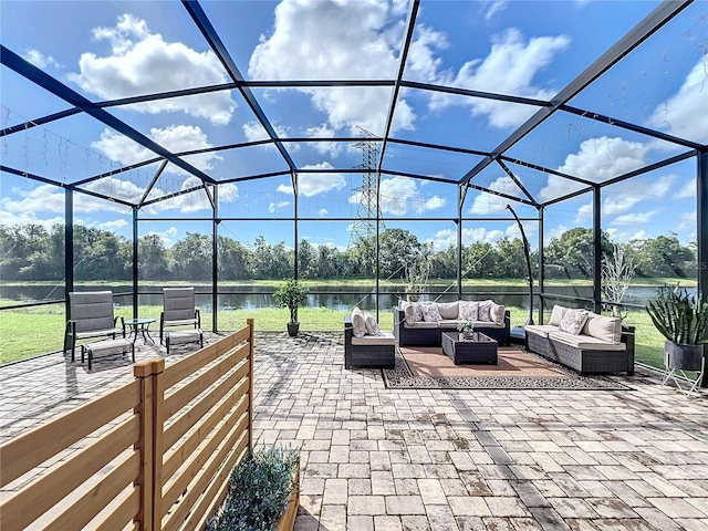 view of patio / terrace featuring outdoor lounge area, glass enclosure, and a water view