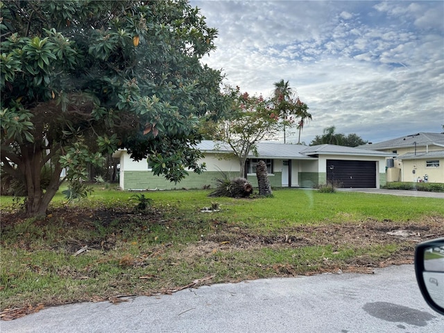 view of front of home with a front yard and a garage