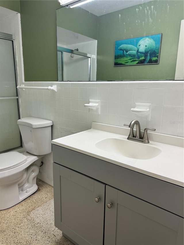 bathroom featuring vanity, decorative backsplash, toilet, tile walls, and an enclosed shower