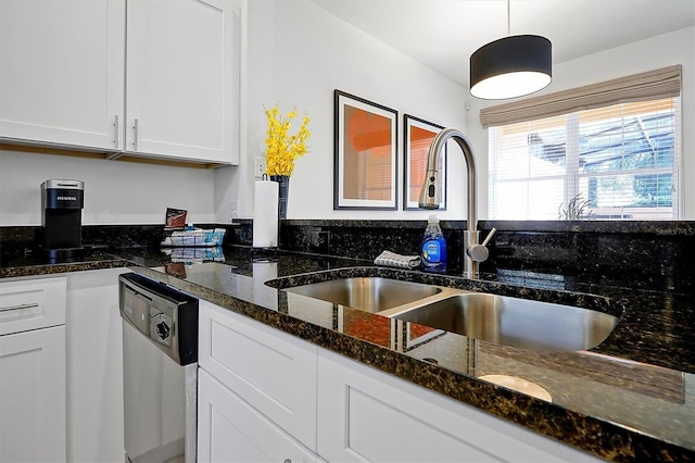 kitchen with decorative light fixtures, white cabinetry, sink, and dark stone counters