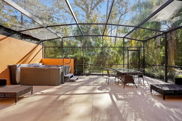 view of patio / terrace featuring glass enclosure and a hot tub