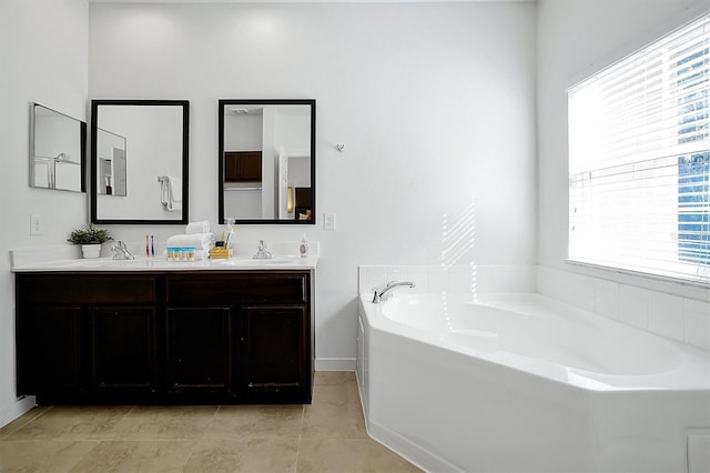 bathroom with tile patterned flooring, vanity, and a bath