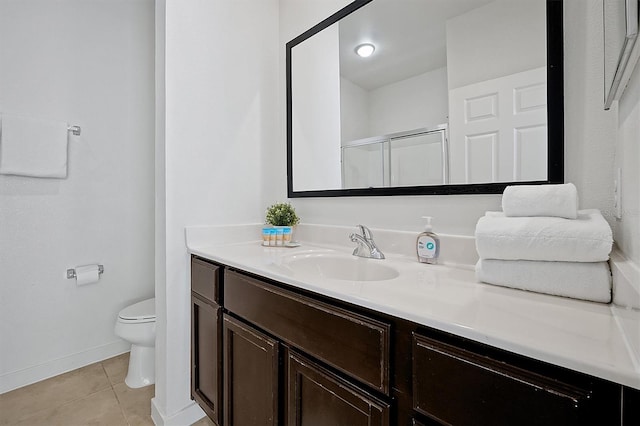 bathroom with toilet, vanity, tile patterned floors, and a shower with door