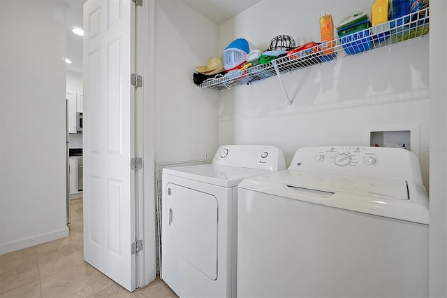 laundry area with washer and clothes dryer and light tile patterned flooring