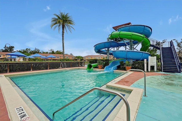 view of swimming pool featuring a water slide and a patio