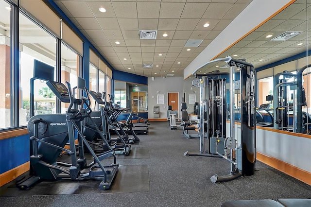 workout area featuring a drop ceiling and plenty of natural light