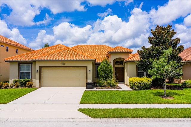 mediterranean / spanish house featuring a front yard and a garage